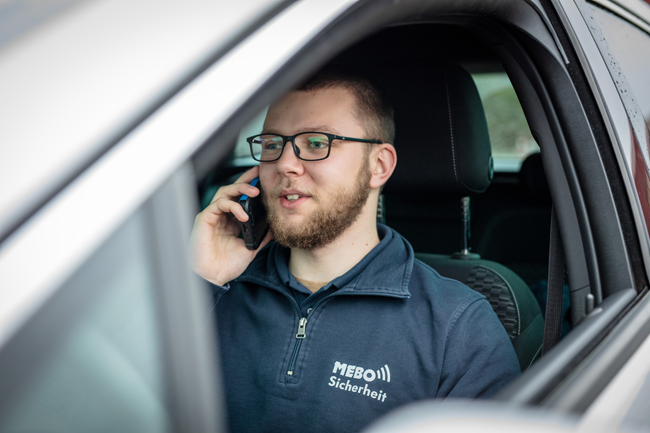 Peer Hoppe telefonierend am Steuer seines geparkten Autos