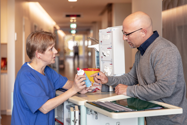 Frau und Mann im Gespräch, Frau mit Plastikflasche in der Hand.